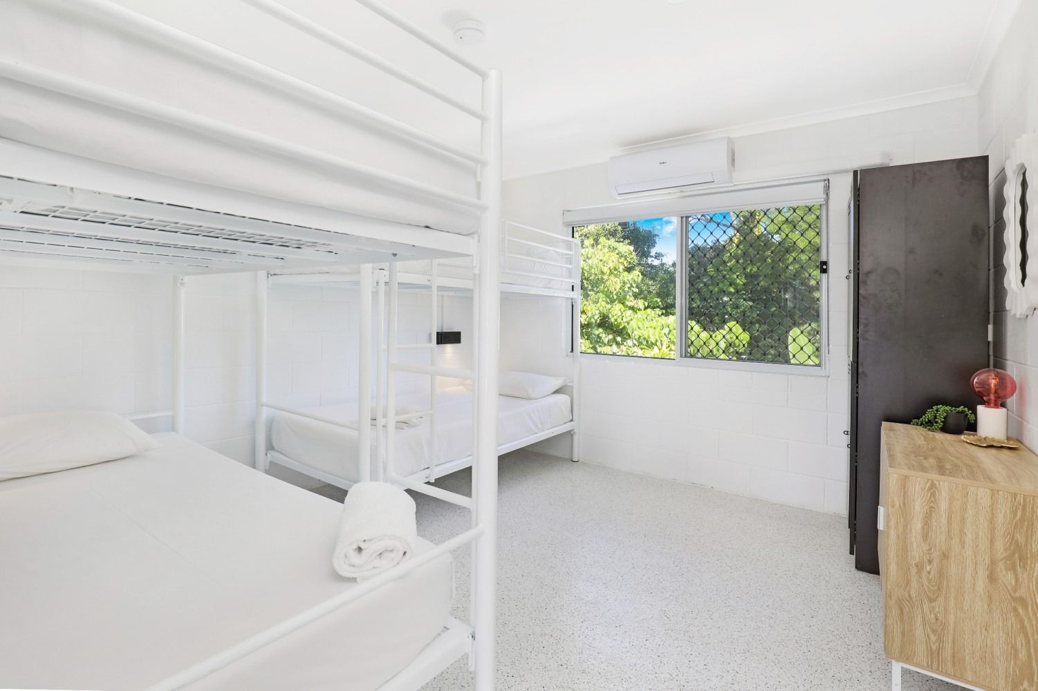 A bedroom with bunk beds and a window.