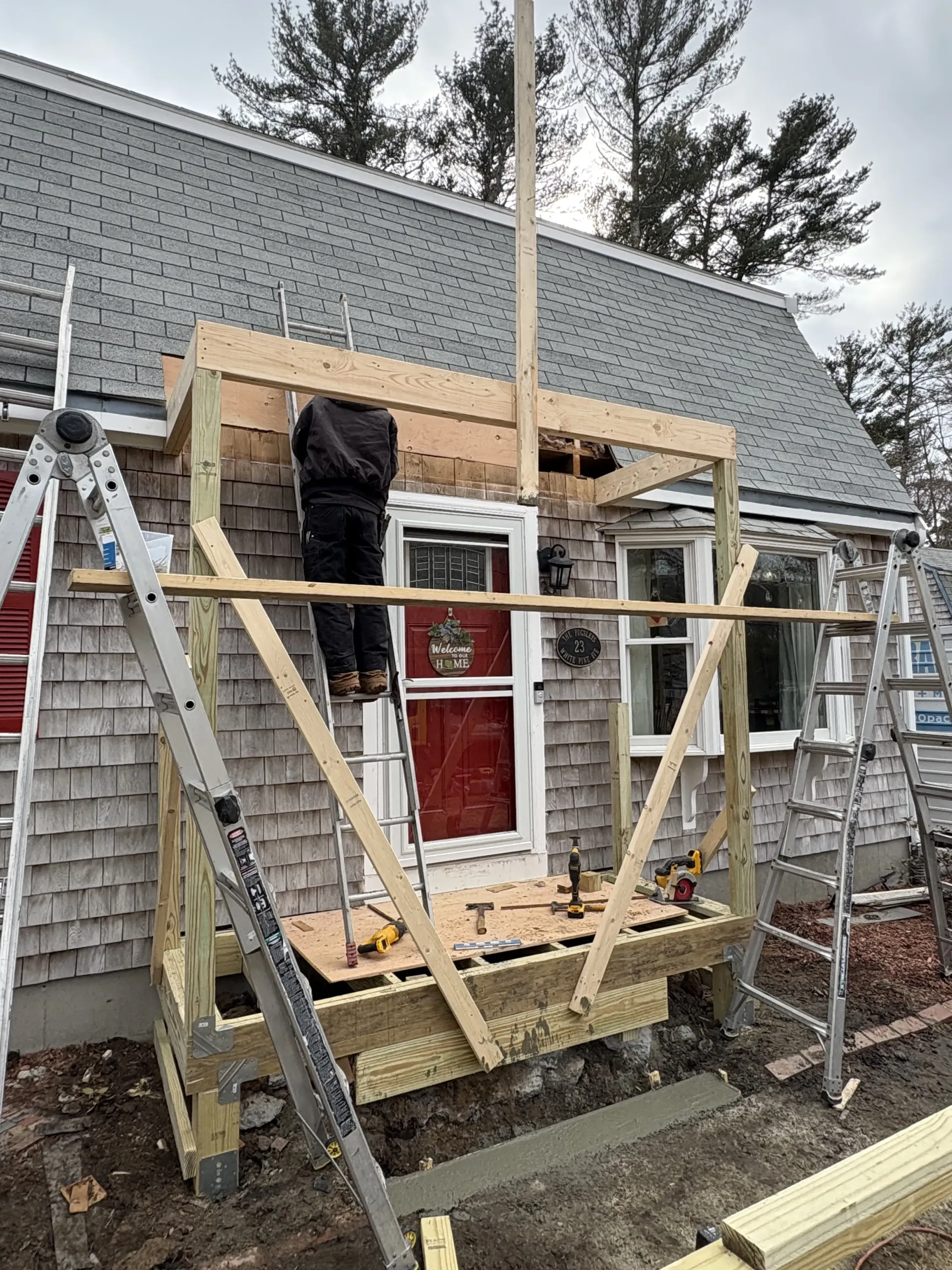 Construction scaffolding around a red door on a house exterior under repair