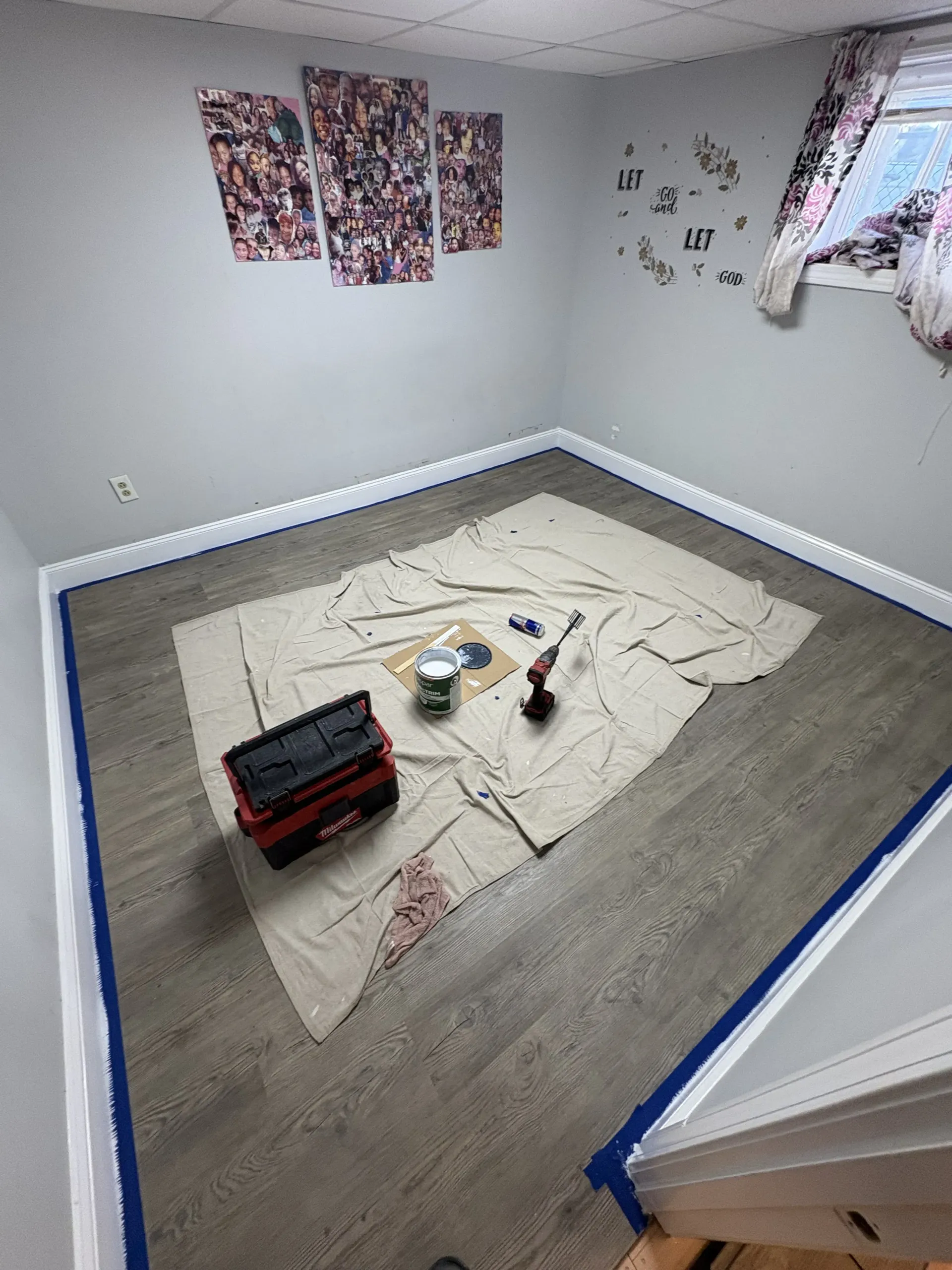Empty room with tape on the floor, tools in the center, and posters on the walls.