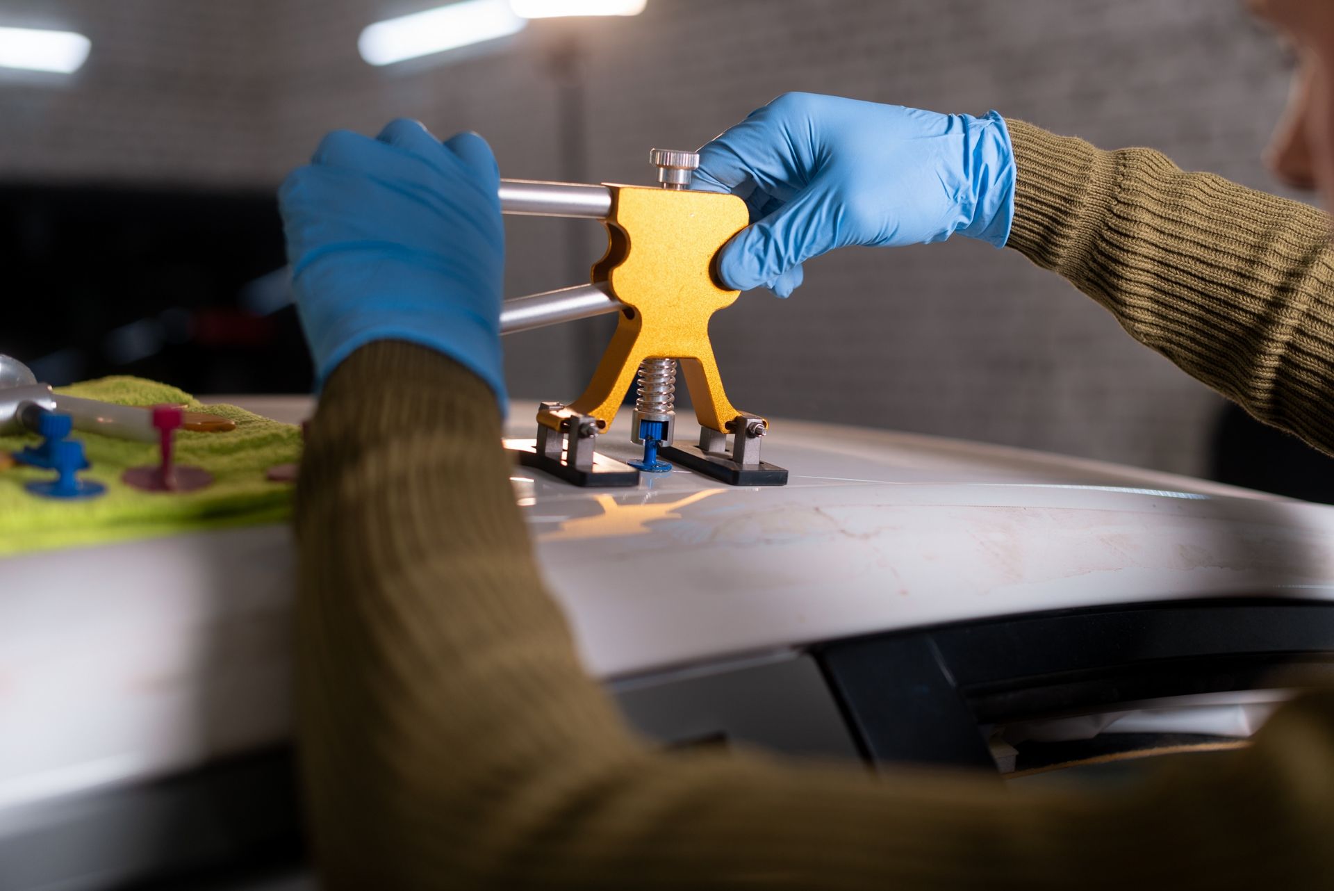 Person wearing blue gloves assembling a yellow drone on a table