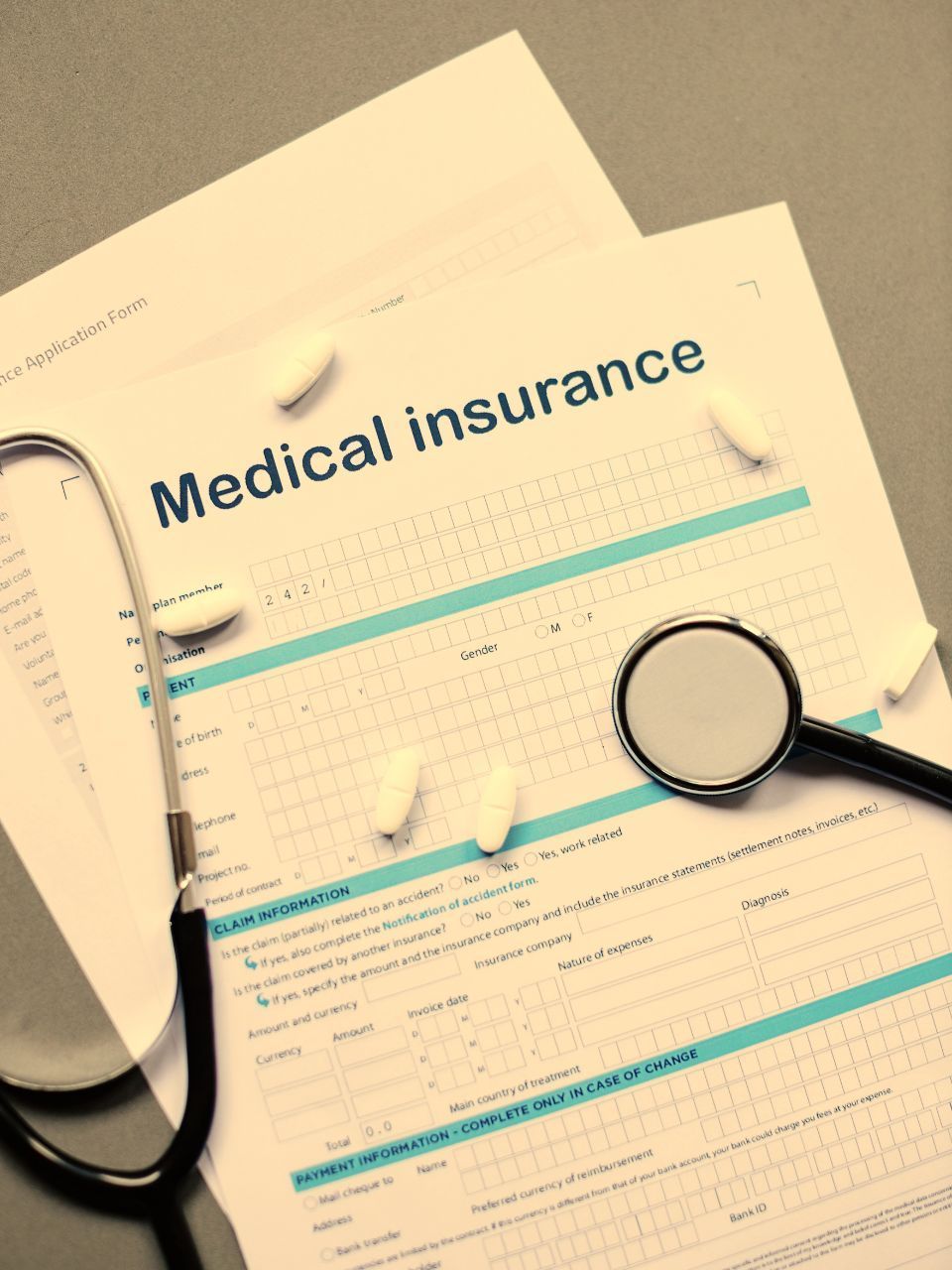 Medical insurance form with stethoscope and pills.