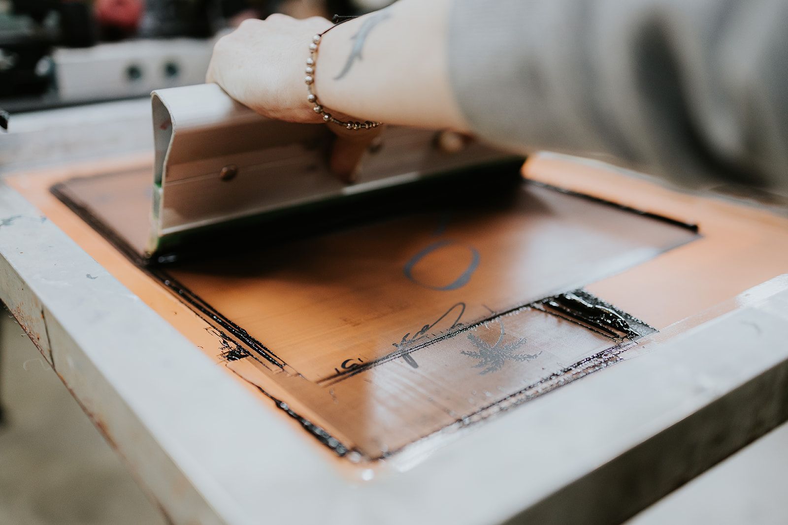 A Person Is Working on A Machine that Is Printing a Piece of Paper — CKM Screen Printing in Woy Woy, NSW