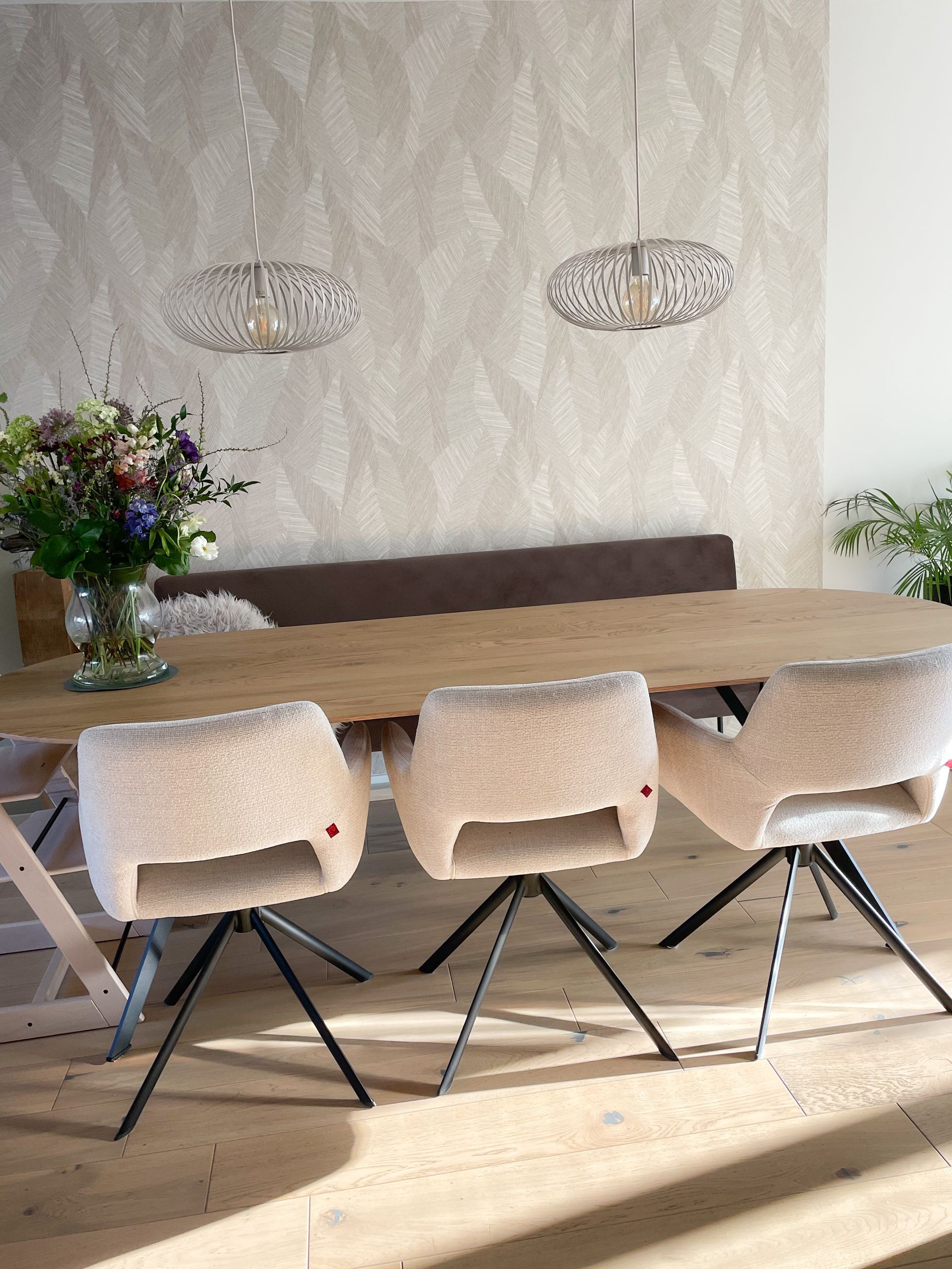 Eethoek met een bank aan de ene zijde en 3 eetkamerstoelen aan de andere kant.