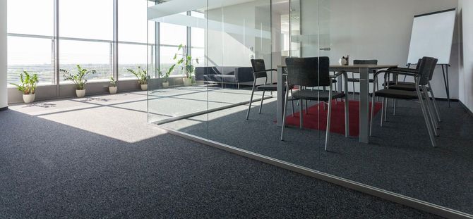 Modern office space with a meeting room and a large window.