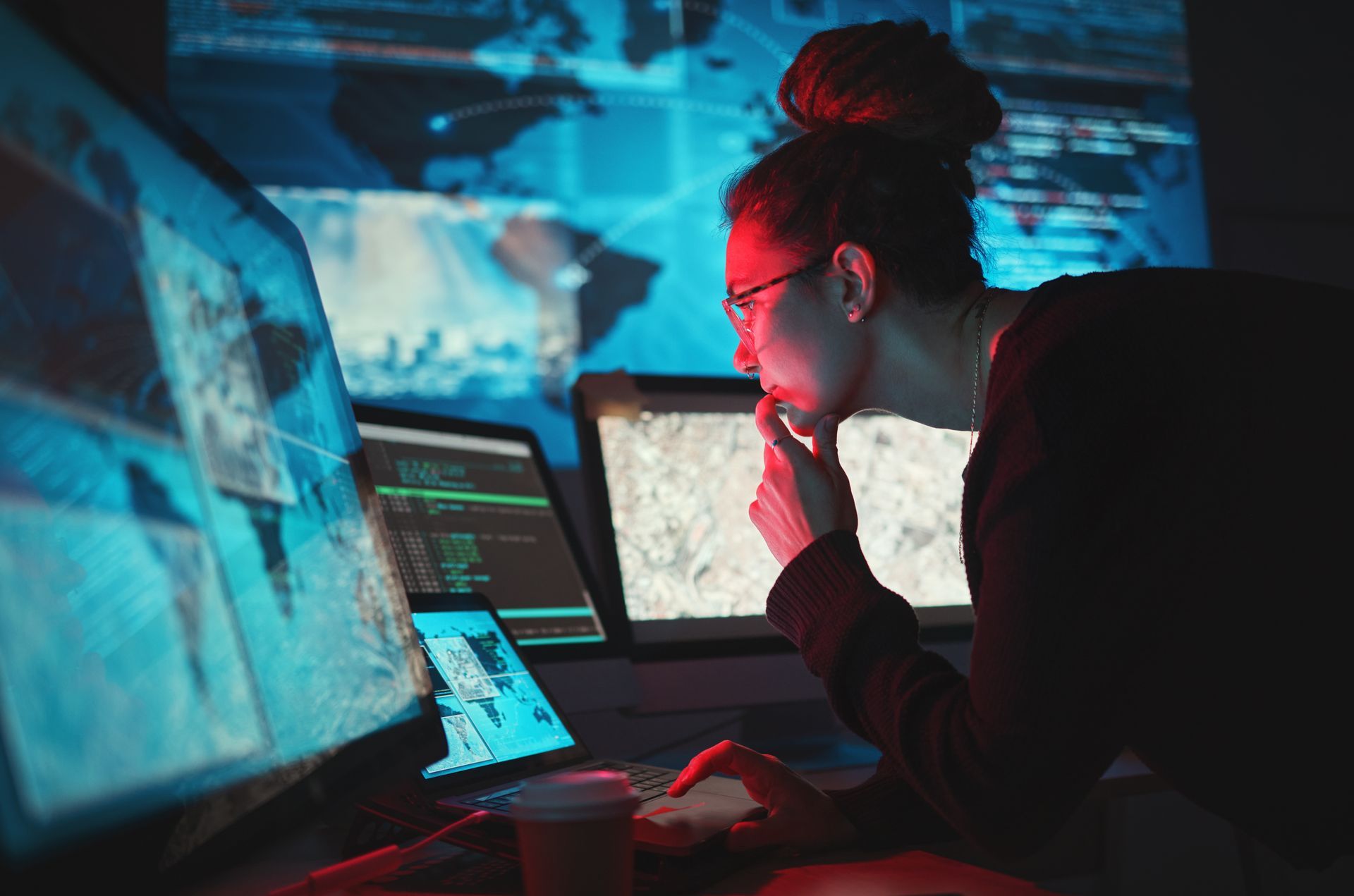 A woman is looking at a computer screen in a dark room.