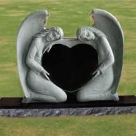 A gravestone with two angels holding a heart in their hands.