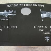 A black gravestone with a plane and an american flag on it.