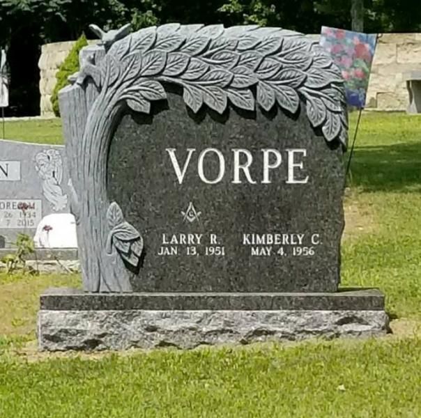 A gravestone for vorpe in a cemetery with a tree carved into it.