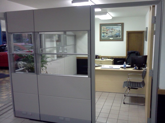 A cubicle with a desk and a chair in it