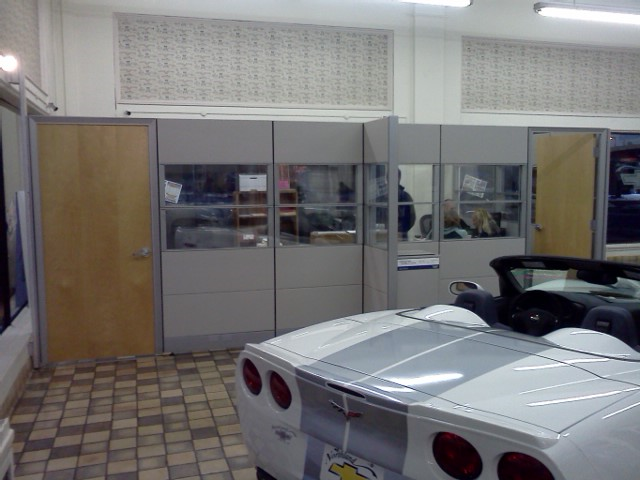 A white sports car is parked in a room