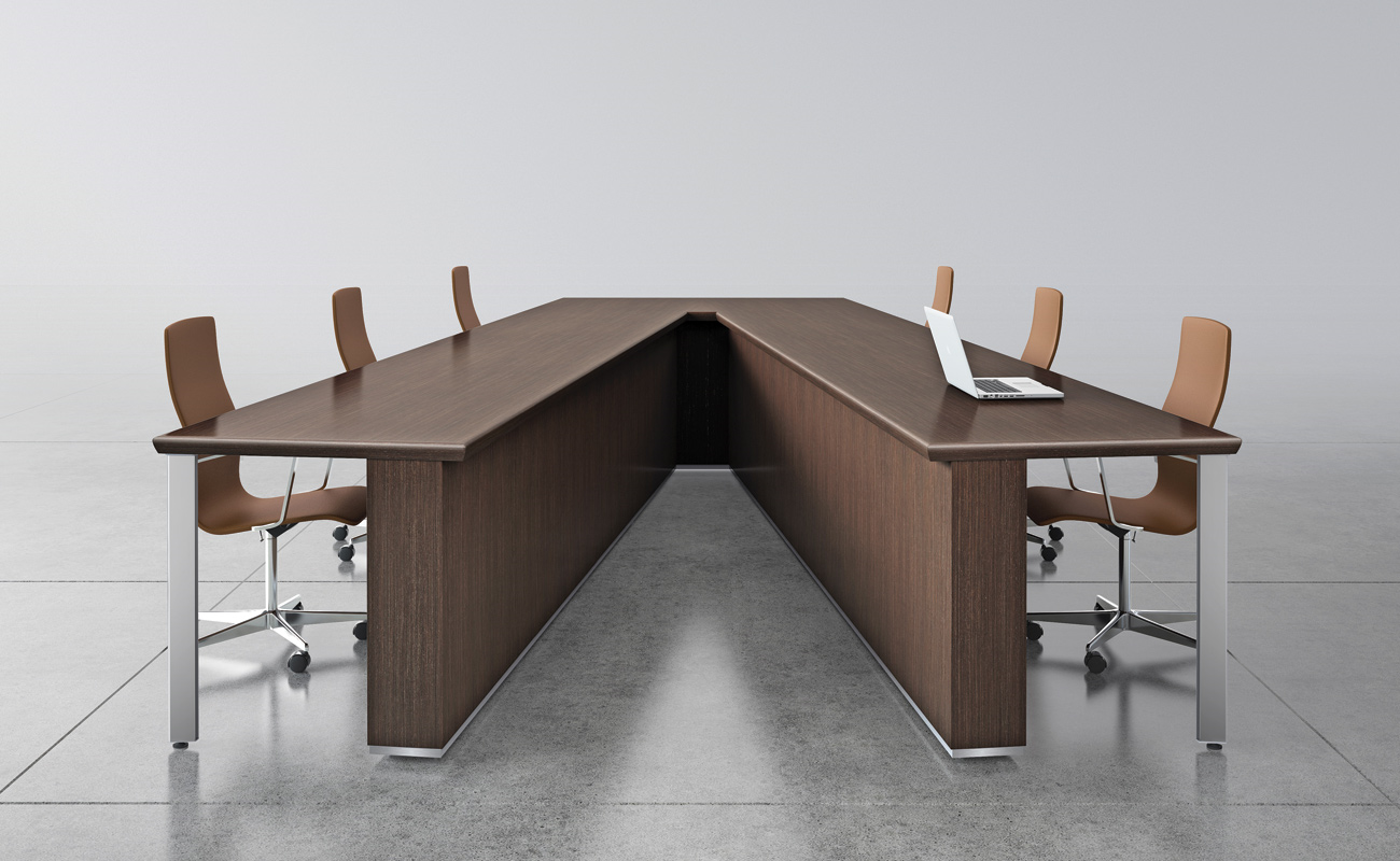 A long conference table with chairs and a laptop on it