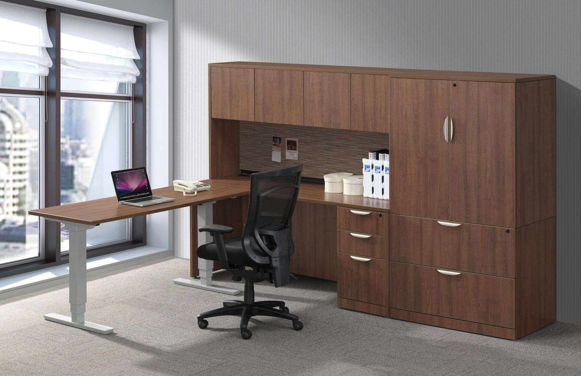 There is a desk with a laptop on it and a chair in the room.
