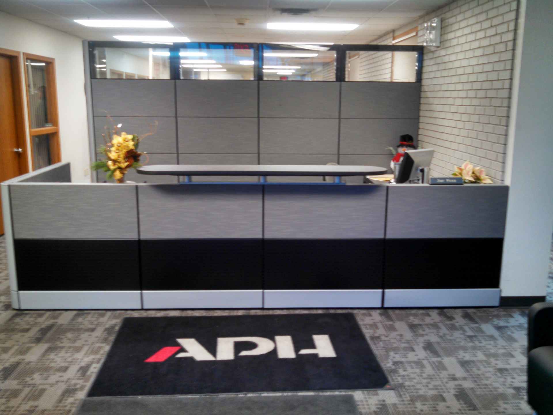 A reception area with a rug that says apl on it