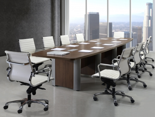 A conference room with a long table and white chairs
