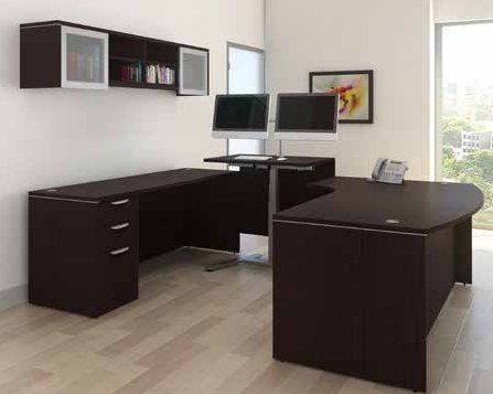 A room with two desks and a computer on a desk.