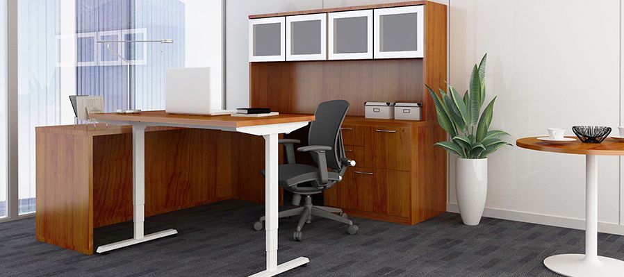A standing desk with a chair and a table in an office.