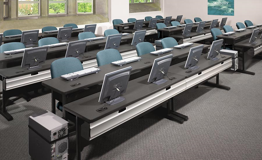 A classroom with a lot of computers on the desks