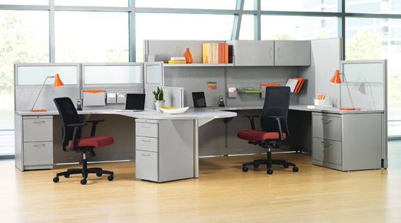 A cubicle with two desks and two chairs in an office