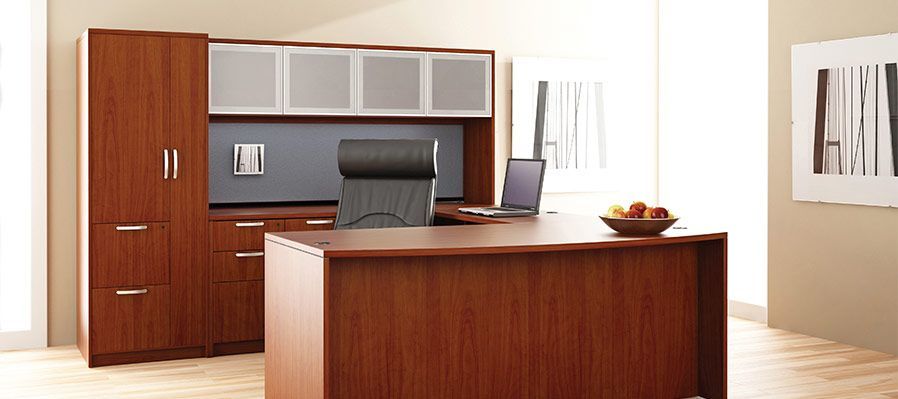 A wooden desk with a chair and a laptop on it