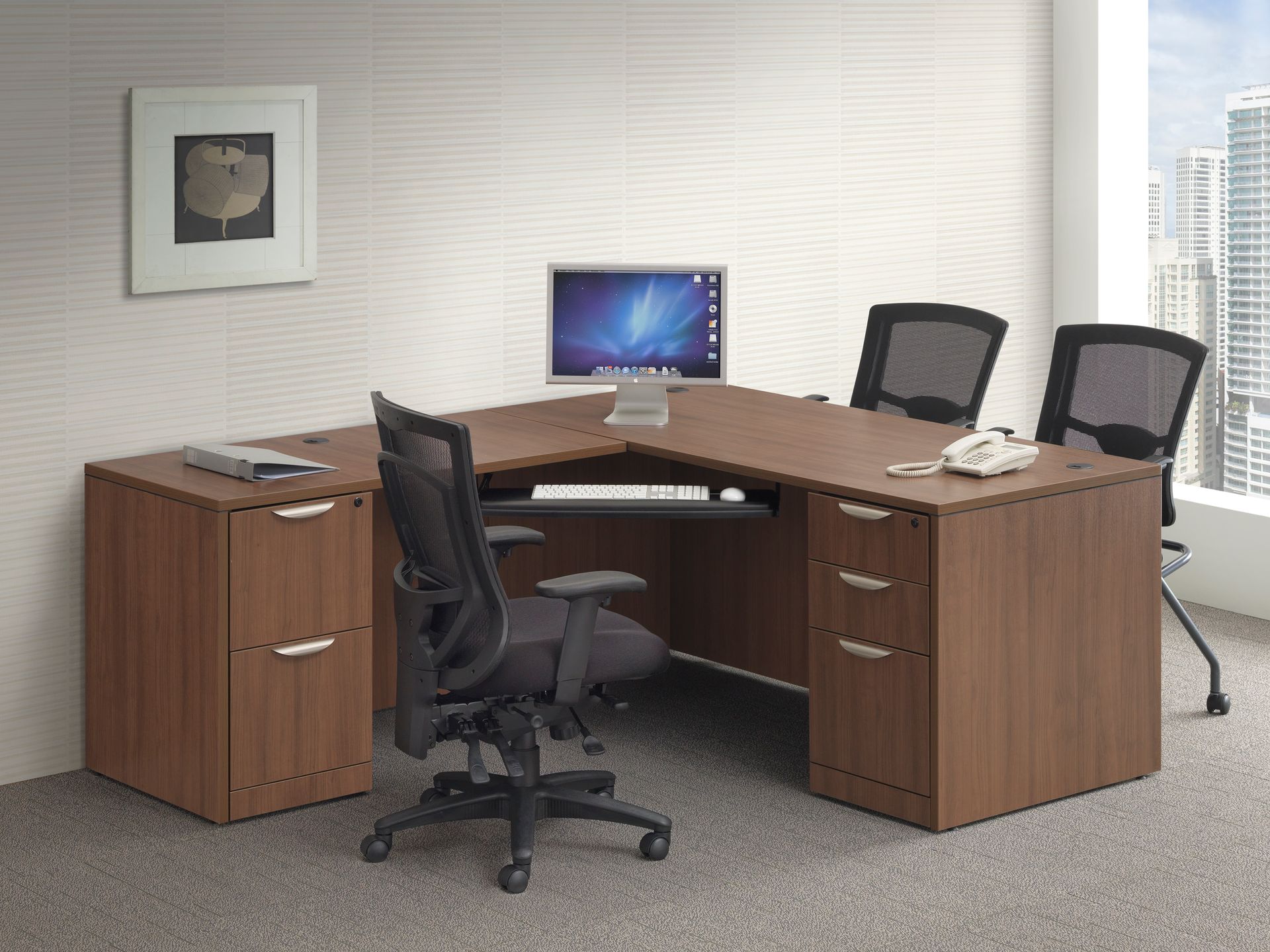 A desk with a computer on it and a chair in an office.