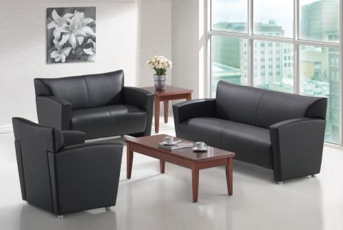 A living room with black leather furniture and a coffee table