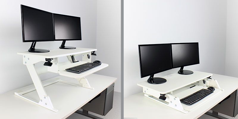 A standing desk with two monitors and a keyboard on it.