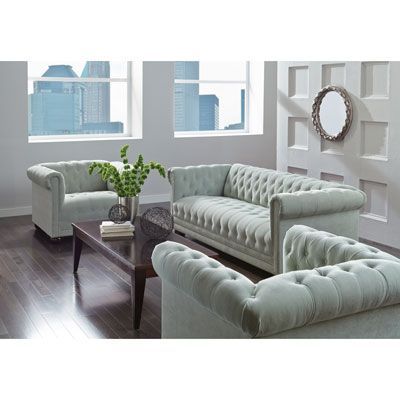 A living room with a couch , two chairs , and a coffee table.