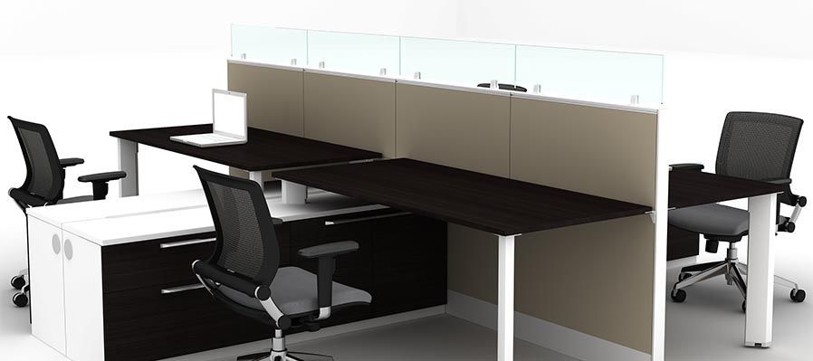 A cubicle with two desks and two chairs with a laptop on the desk.