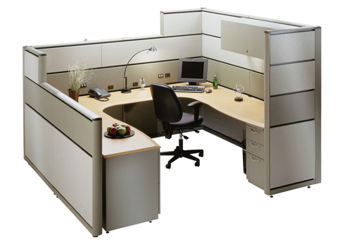 A cubicle with a desk and chair with a computer on it