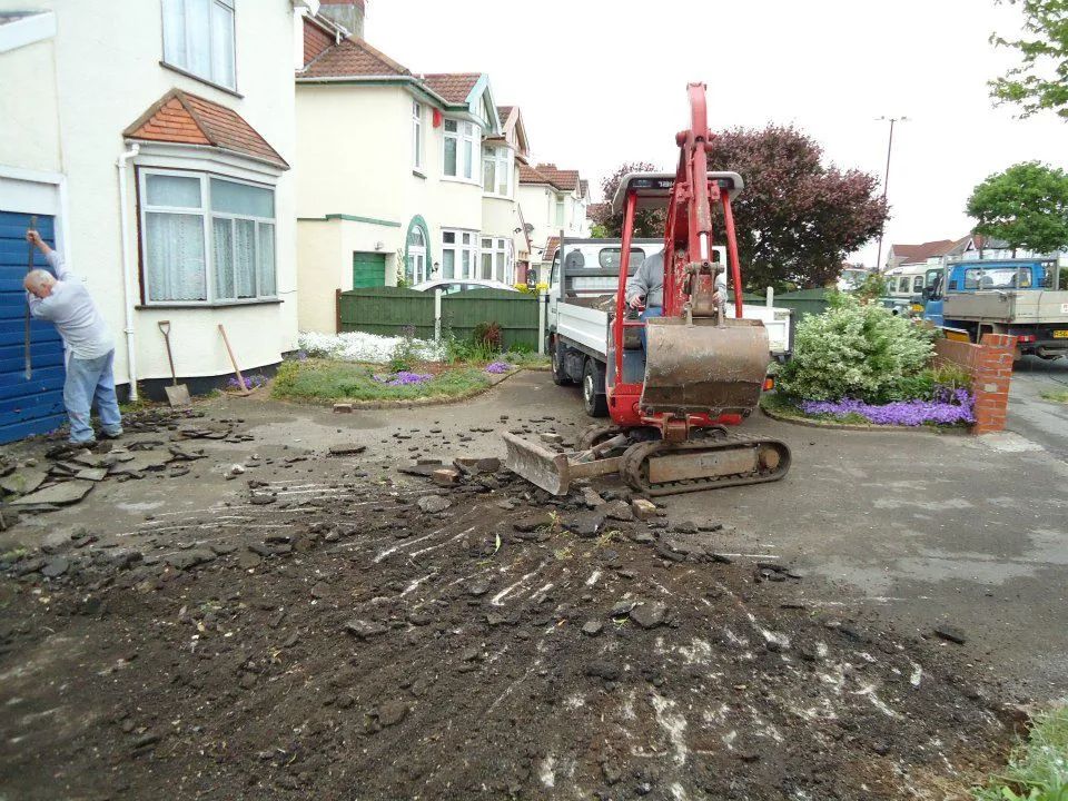 Urban Paving Bristol | A man is digging in the dirt in front of a house.