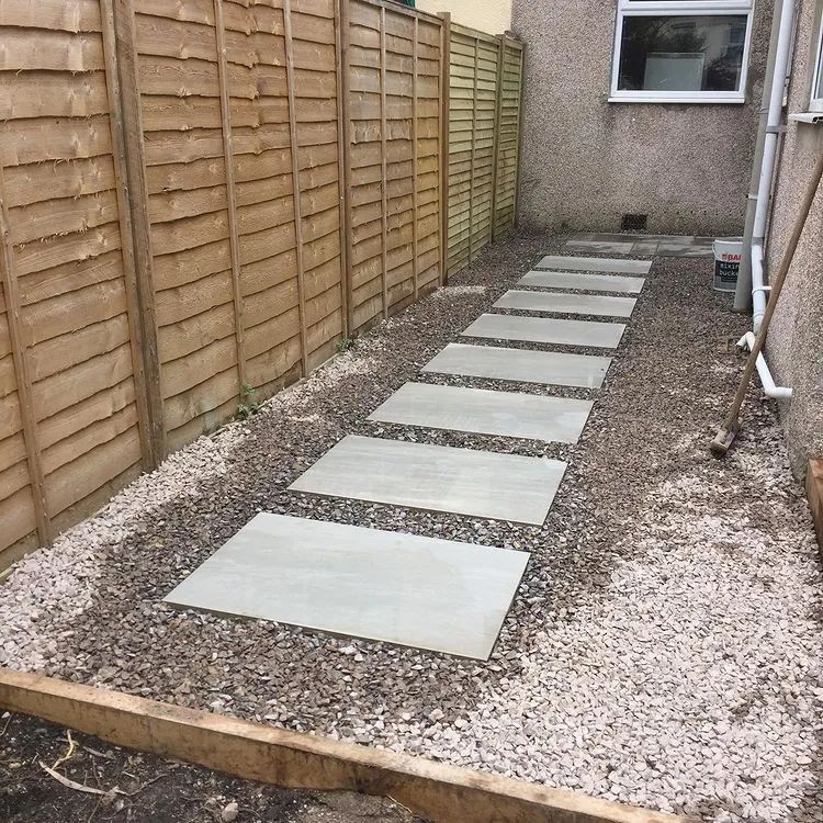 Urban Paving Bristol | A wooden fence surrounds a concrete walkway in a garden.