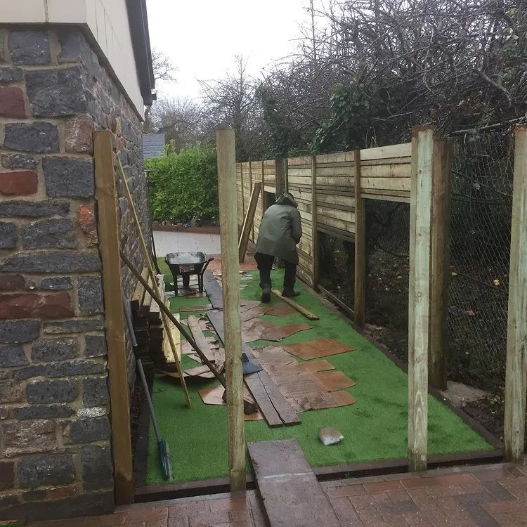 Urban Paving Bristol | Two men are working on a wooden fence in a back garden