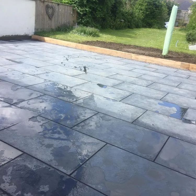 Urban Paving Bristol | A patio with a lot of tiles and a fence in the background.