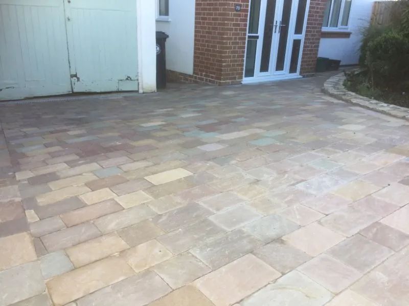 Urban Paving Bristol | A brick driveway in front of a house with a garage door.