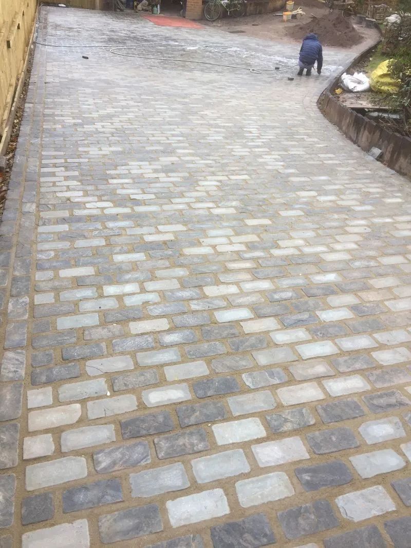 Urban Paving Bristol | A man is walking down a cobblestone driveway.
