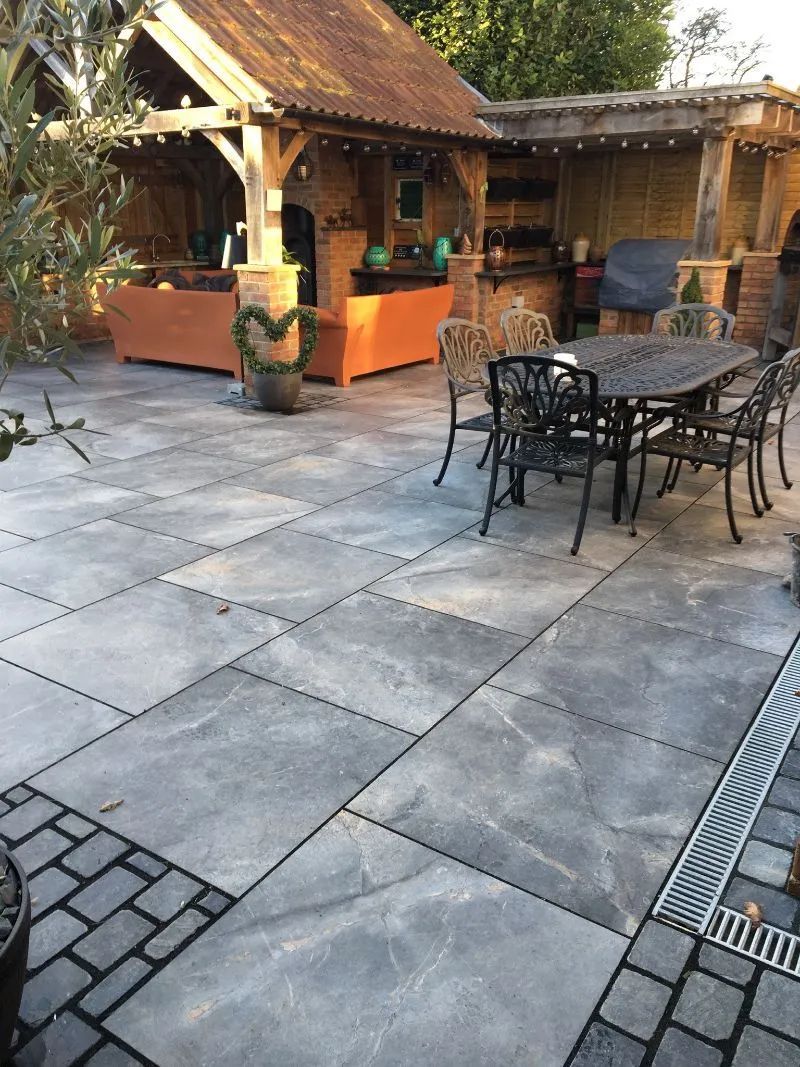 Urban Paving Bristol | A patio with a table and chairs in front of a house.