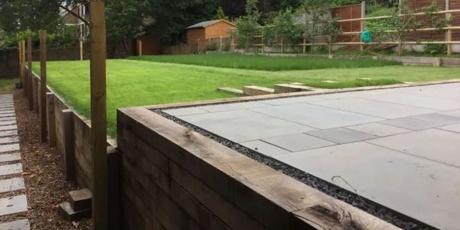 Urban Paving Bristol | A wooden fence surrounds a lush green lawn in a back garden.