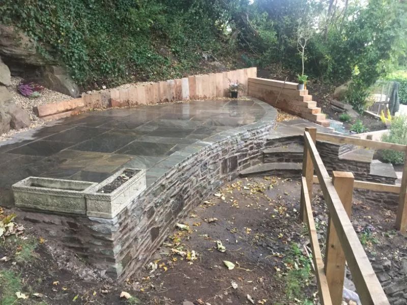 Urban Paving Bristol | A wooden fence surrounds a concrete area in a garden.
