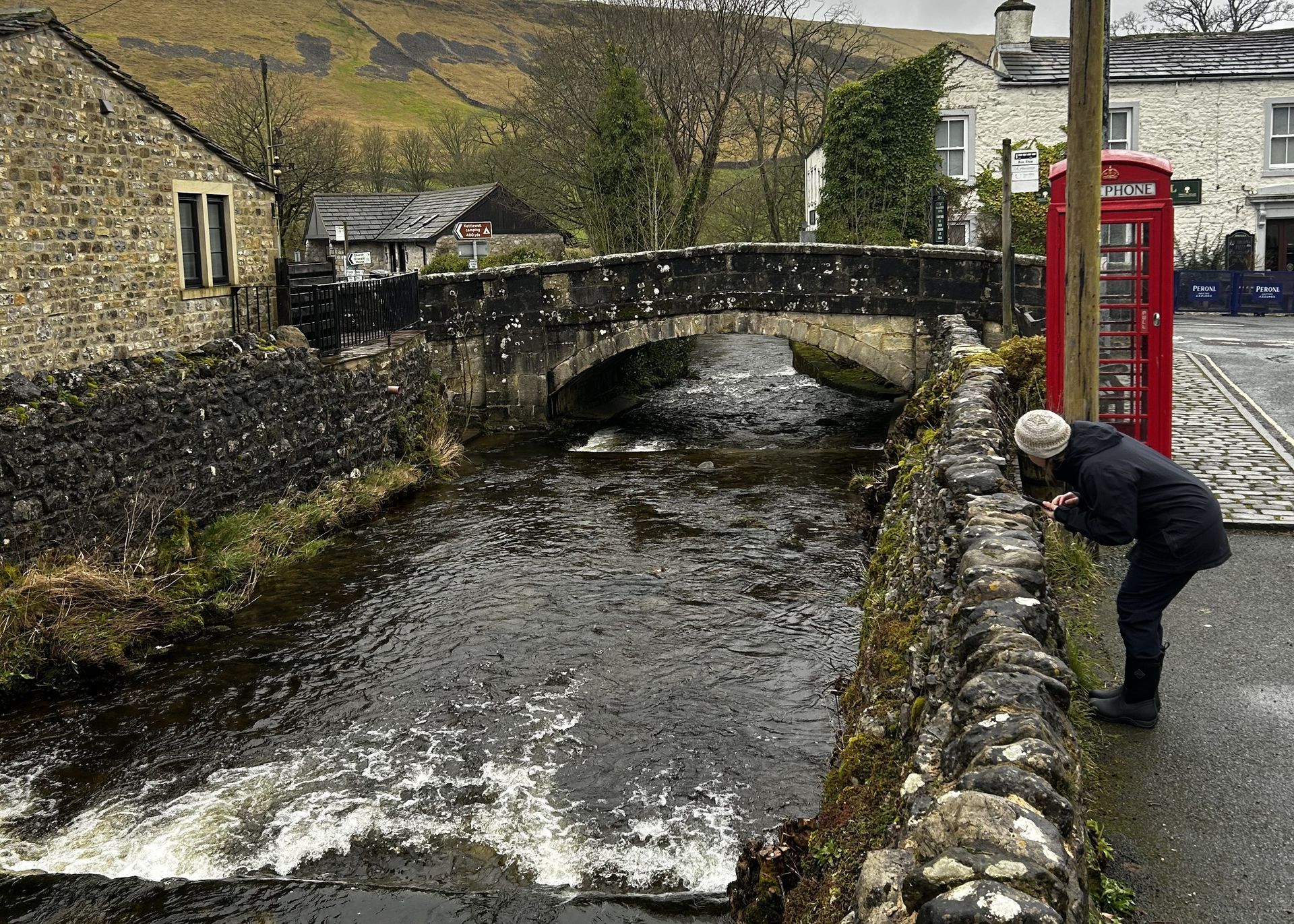 a woman reviewing weirs in a village beck.