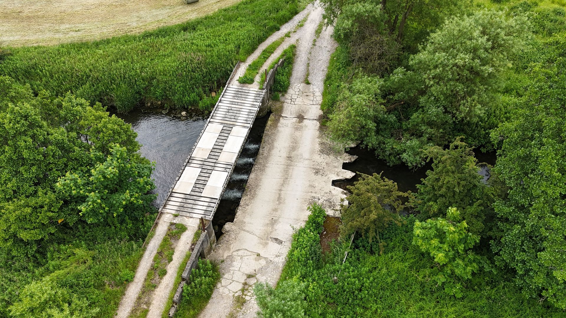 old bridge next to a concrete ford which has four pipes allowing the stream water through