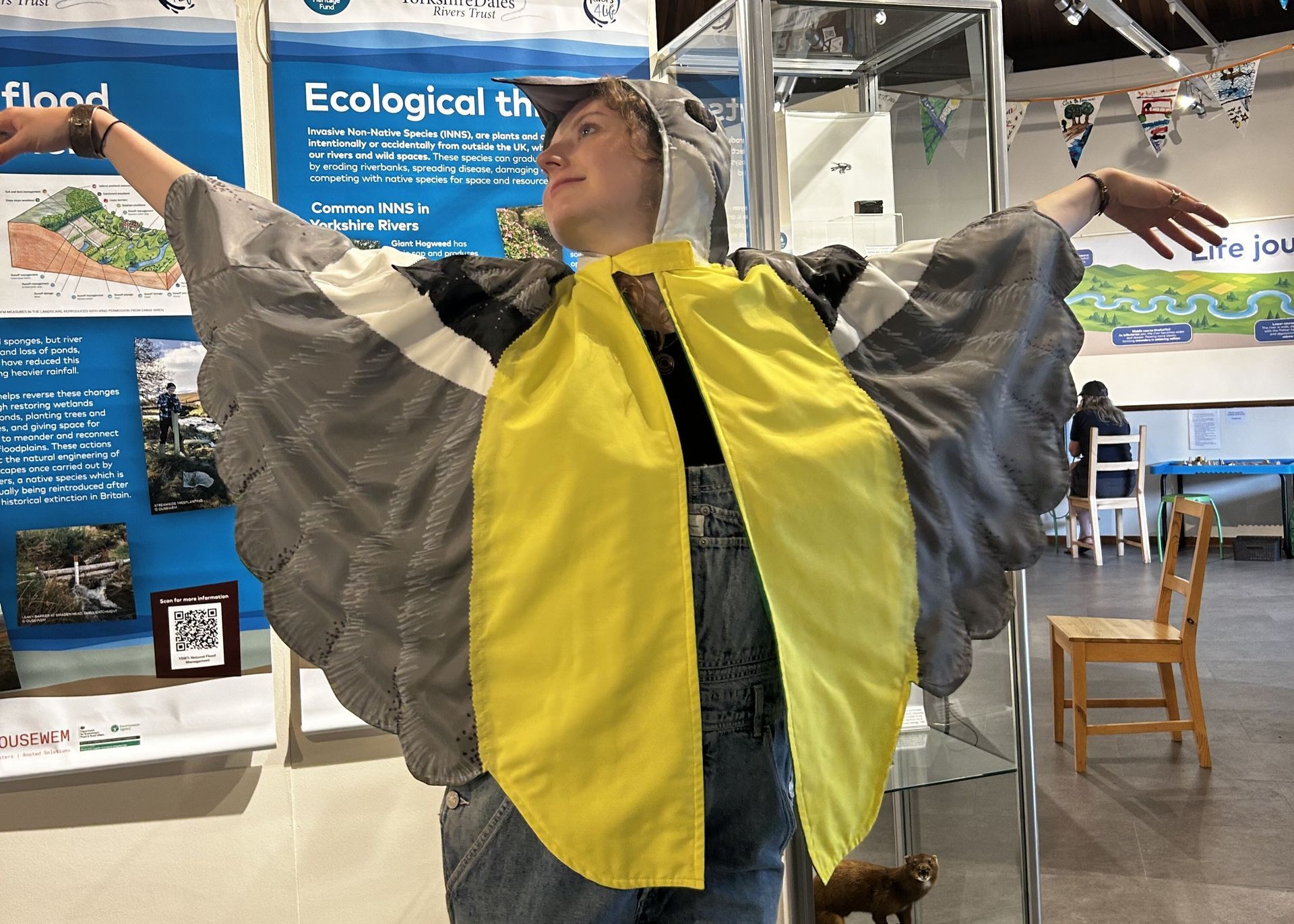 Young person dressed as a grey lapwing with their arms outspread.