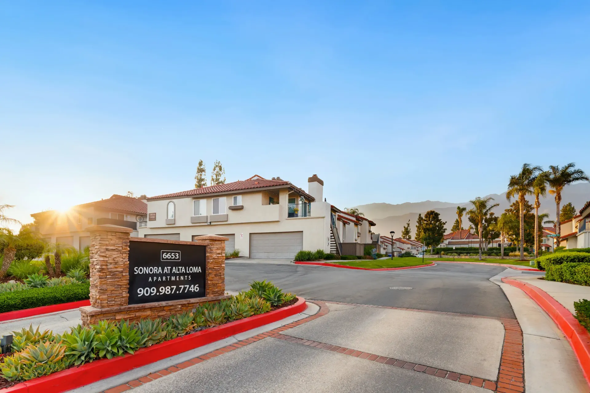 Exterior view of an apartment community entrance with signage and landscaping at Sonora at Alta Loma apartments in Alta Loma, CA.