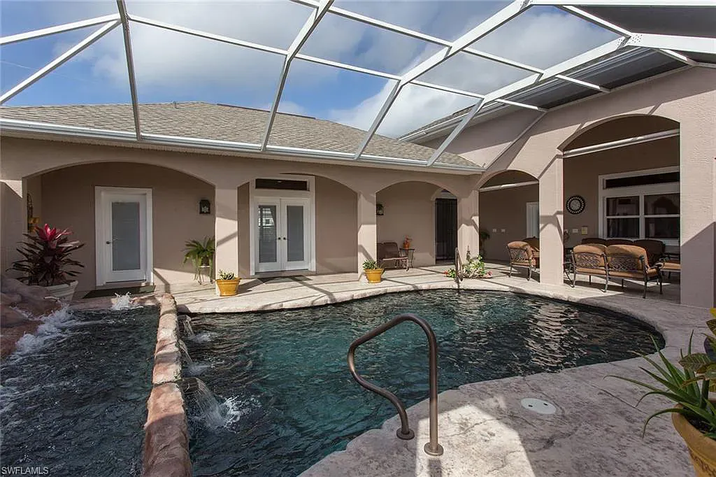 Pool enclosed by a roofed patio. Tan walls, pool, and sky visible.