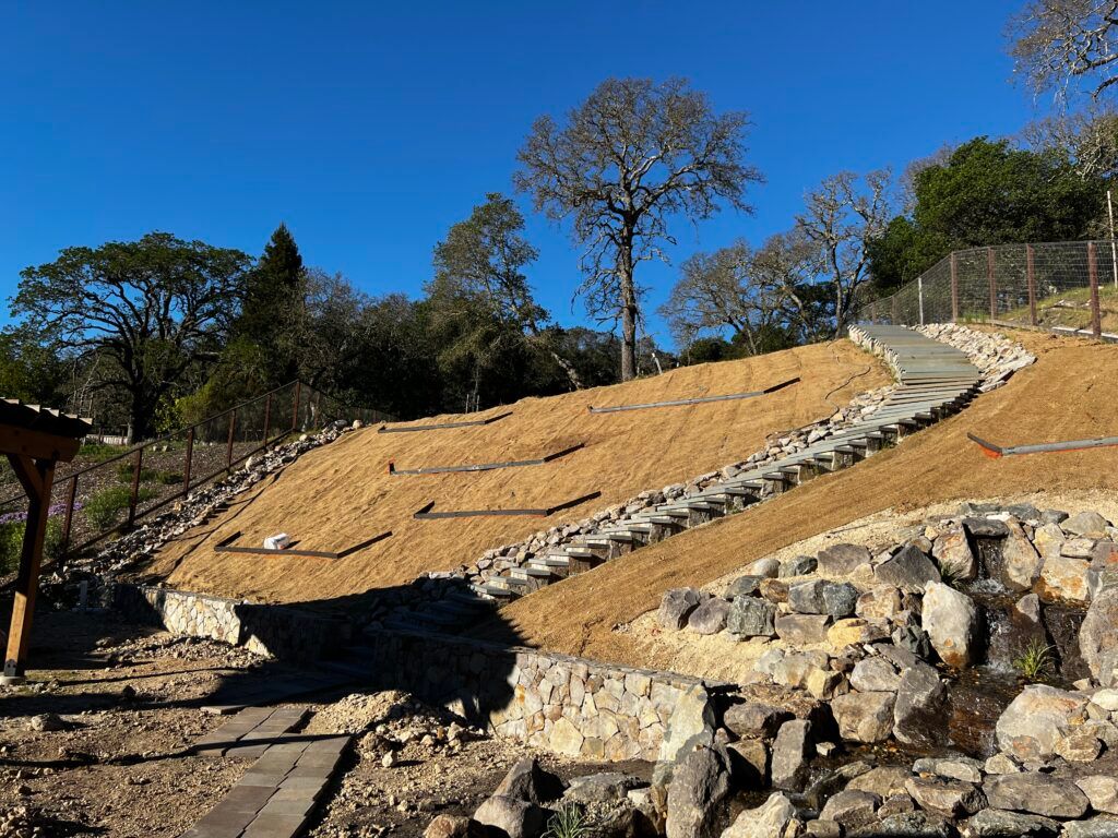A staircase going up a hill with trees in the background.