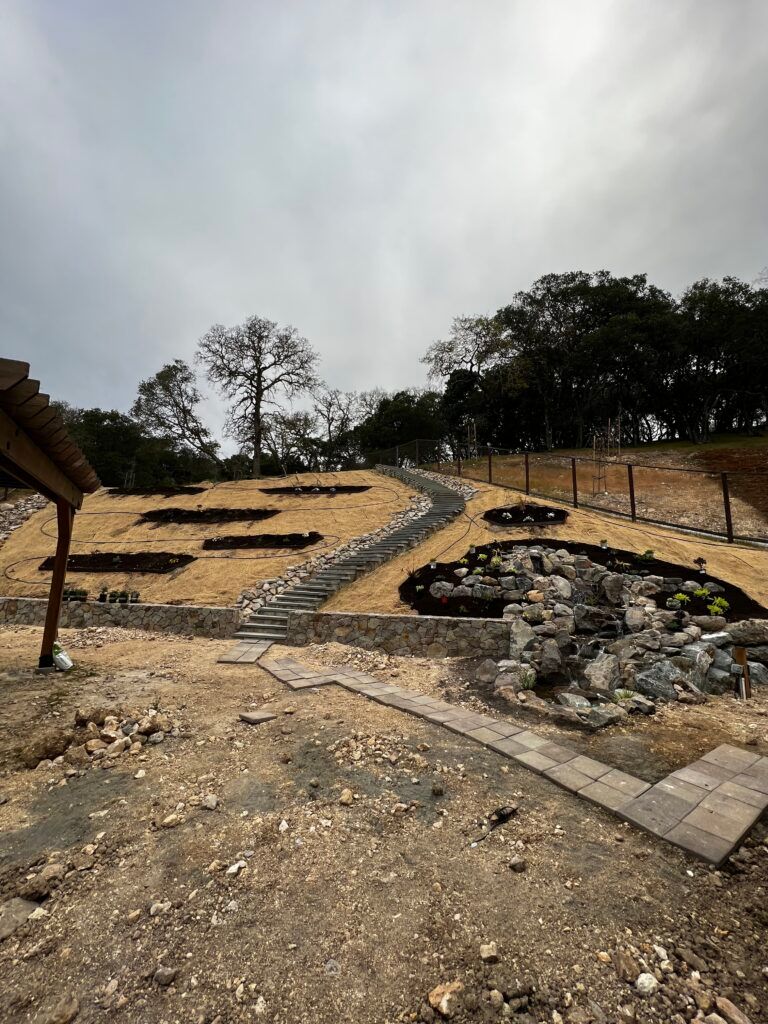 A dirt field with trees in the background and stairs leading up to it.