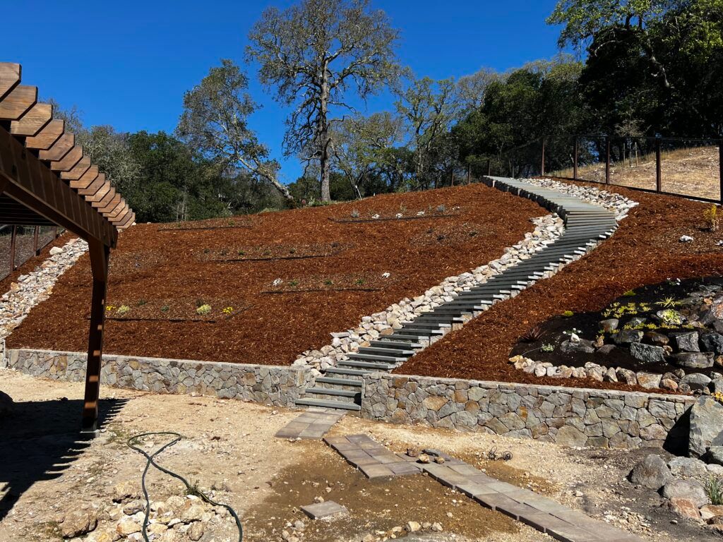 A set of stairs leading up to a hill with trees in the background.