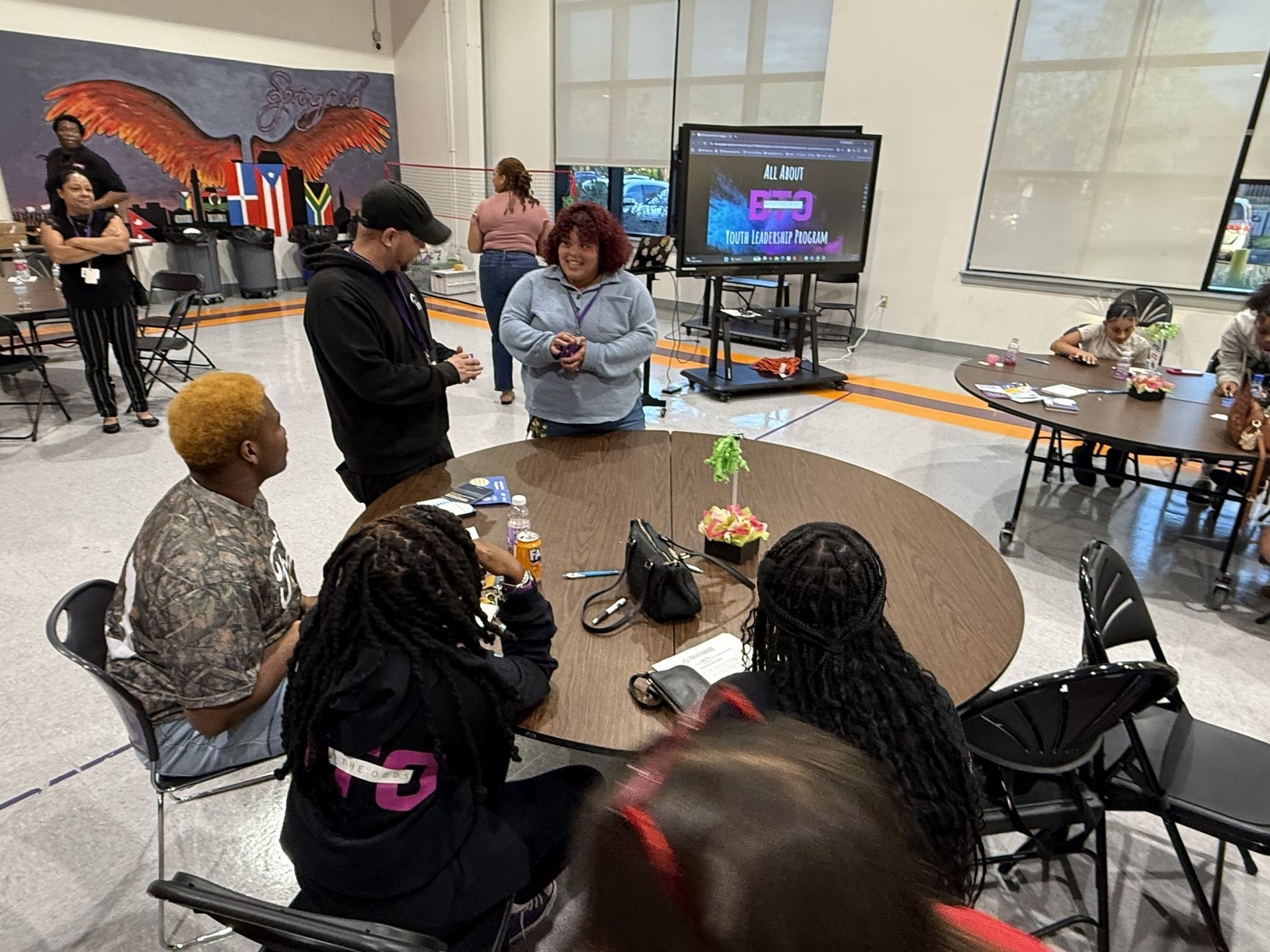 people sitting on table,people standing and smiling at each other