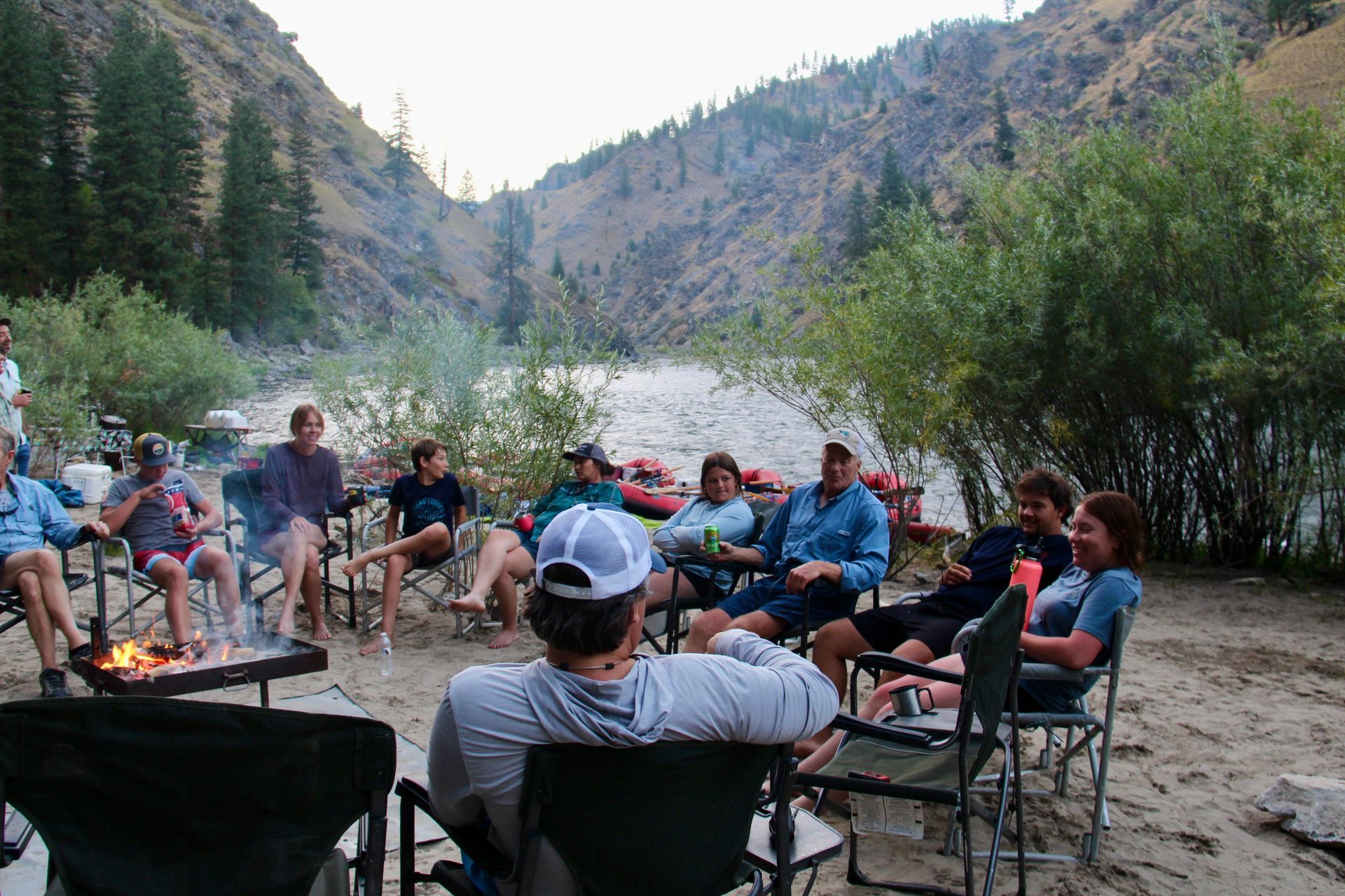 A group of people are sitting around a campfire.