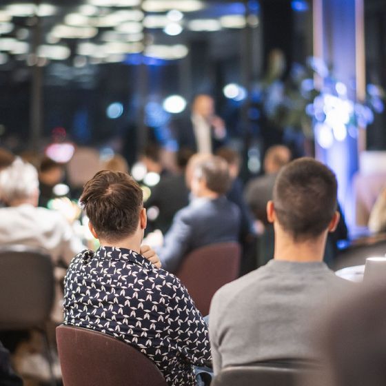 A group of people are sitting in chairs watching a presentation