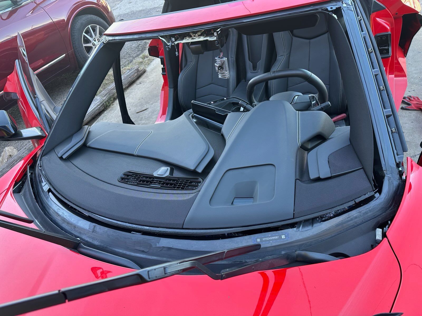 Red sports car with rear window showing a stripped interior and exposed seats in the back.